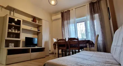 a bedroom with a bed and a table and a television at Holiday home Telese Roma in Rome