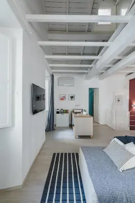 a white room with a bed and a desk at La Casetta a Monti in Rome