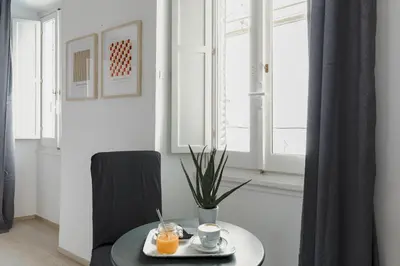 a table with a plate of food on it in a room with windows at La Casetta a Monti in Rome