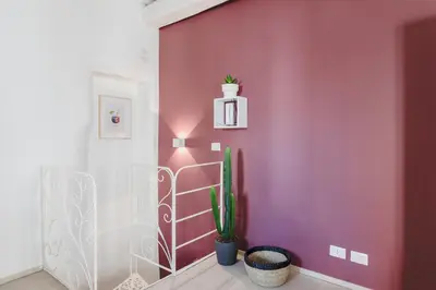 a hallway with a pink wall with a cactus at La Casetta a Monti in Rome