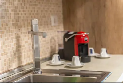 a kitchen sink with a red appliance on a counter at Large Garden in Rome