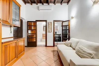 a living room with a couch and a kitchen at GIULIO CESARE DELUXE - Spanish Step RomeDreamHome in Rome