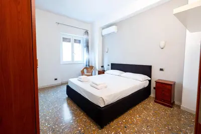 a bedroom with a large bed with white sheets at Casa Di Cristina in Rome