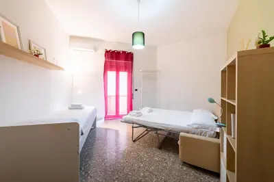 a room with two beds and a red window at Casa Di Cristina in Rome