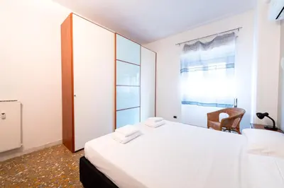 a bedroom with a bed and a chair and a window at Casa Di Cristina in Rome