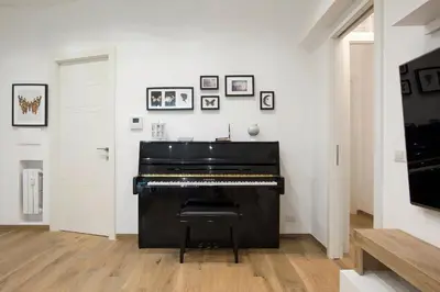 a black piano in a room with pictures on the wall at Domus Ascanio by the Vatican in Rome