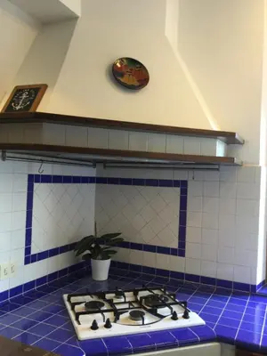 a stove top in a kitchen with blue tiles at Sun's House in Rome