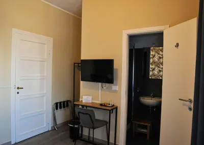 a room with a desk and a sink and a television at Guest House Prime Palace in Rome
