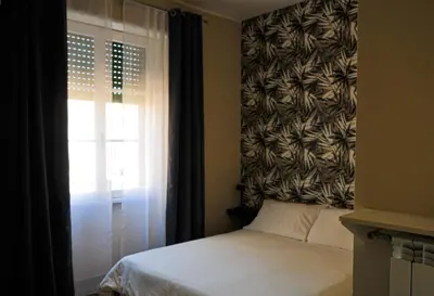 a bedroom with a bed and a window with a curtain at Guest House Prime Palace in Rome