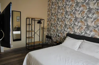 a bedroom with a white bed and a floral wallpaper at Guest House Prime Palace in Rome