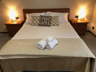 a bedroom with two towels on a bed with two lamps at Interno 18 - appartamento a San Giovanni in Rome