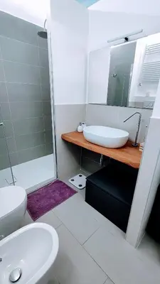 a bathroom with a sink and a toilet and a mirror at Attic Roof Oasi Vaticana in Rome