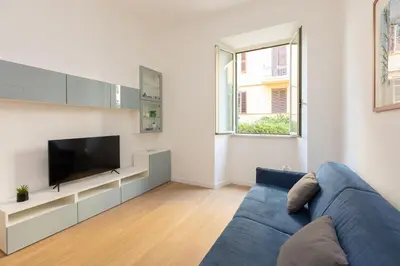 a living room with a blue couch and a tv at Faleria by Rental in Rome in Rome