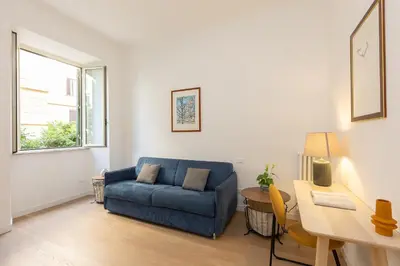 a living room with a blue couch and a desk at Faleria by Rental in Rome in Rome