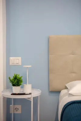 a table with a plant on it next to a bed at 633 APPIA DESIGN ROOM in Rome