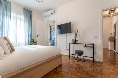 a bedroom with a large bed and a television on the wall at YCH-Bright and cozy flat in Pigneto in Rome