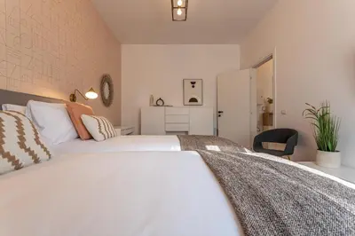 a bedroom with a large white bed and a chair at YCH-Bright and cozy flat in Pigneto in Rome