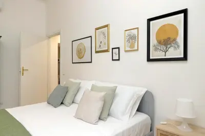 a bedroom with a white bed with pictures on the wall at YCH-Grazioso Bilocale vicino al Vaticano in Rome