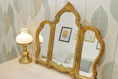 a gold mirror on a table next to a lamp at YCH-Grazioso Bilocale vicino al Vaticano in Rome