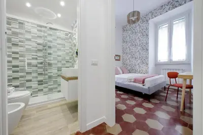a bedroom with a bed and a bathroom with a shower at YCH-Grazioso Bilocale vicino al Vaticano in Rome