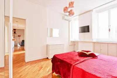 a white room with a bed with a red blanket at Piazza Navona - Roma Centro Storico in Rome