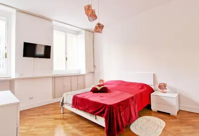 a white bedroom with a bed with a red blanket at Piazza Navona - Roma Centro Storico in Rome
