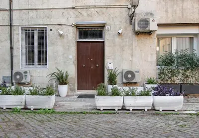 a row of white pots of plants in front of a door at Piazza Navona - Roma Centro Storico in Rome