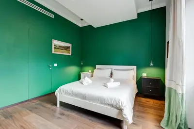 a bedroom with green walls and a white bed at Music Bridge Apartment in Rome