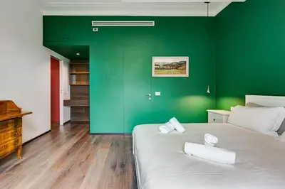 a green room with a bed with towels on it at Music Bridge Apartment in Rome
