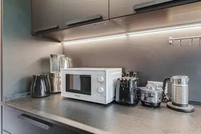 a kitchen counter with a white microwave on a counter top at Music Bridge Apartment in Rome