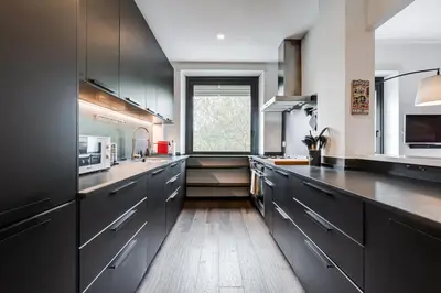 a large kitchen with black cabinets and a window at Music Bridge Apartment in Rome