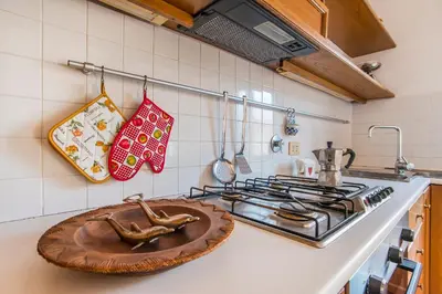a kitchen with a stove with a wooden tray on the counter at Antica Dimora al Vaticano in Rome