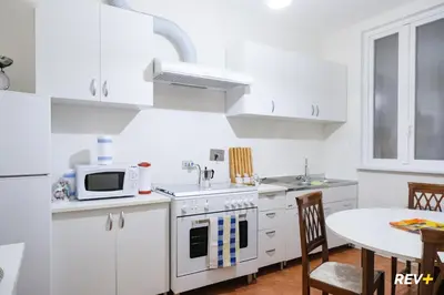 a white kitchen with a table and a microwave at Pantera Holiday House in Rome