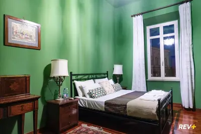 a green bedroom with a bed and a window at Pantera Holiday House in Rome