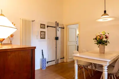 a dining room with a table with a vase of flowers at Casa Cecilia Roma in Rome
