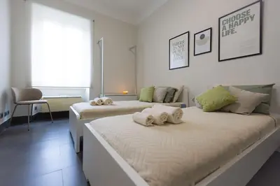 two beds in a white room with towels on them at MC Apartment San Giovanni in Rome
