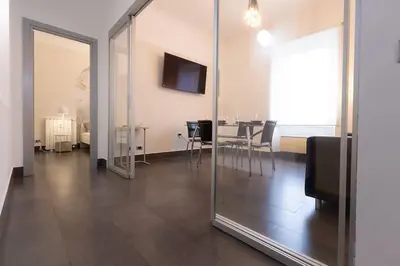 a room with a table and chairs and a mirror at MC Apartment San Giovanni in Rome