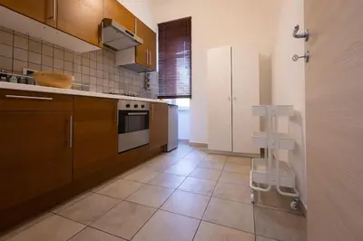 a kitchen with brown cabinets and a white appliance at MC Apartment San Giovanni in Rome
