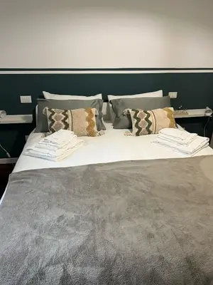 a large bed with several pillows on it at Orti18 - Ponte Milvio in Rome