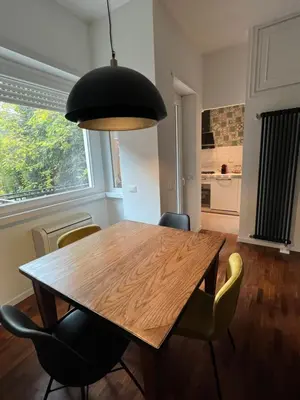 a dining room with a wooden table and chairs at Orti18 - Ponte Milvio in Rome