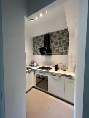 a kitchen with white cabinets and a stove top oven at Orti18 - Ponte Milvio in Rome