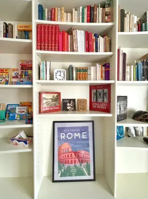 a book shelf filled with books and a framed picture at Luxury Apartment - Centro Storico San Pietro in Rome