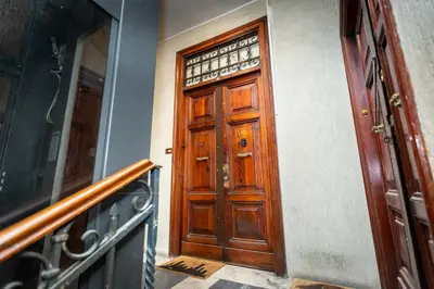 a wooden door in a building with a stair case at Luxury Apartment - Centro Storico San Pietro in Rome