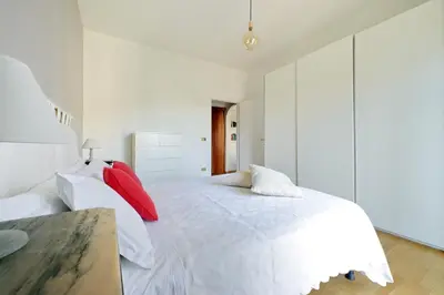 a bedroom with a white bed with red pillows at YCH-Confortevole appartamento vicino Ponte Milvio in Rome