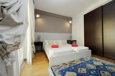 a bedroom with a white bed with red pillows on it at YCH-Confortevole appartamento vicino Ponte Milvio in Rome