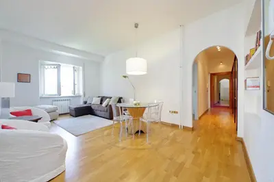 a white living room with a table and a couch at YCH-Confortevole appartamento vicino Ponte Milvio in Rome