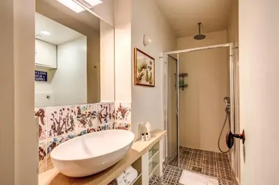 a bathroom with a white sink and a shower at YourSuiteRome in Rome