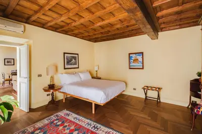 a bedroom with a bed and a wooden ceiling at YourSuiteRome in Rome