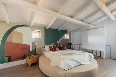 a bedroom with a large bed with a round ottoman at iFlat The Great Beauty in Rome