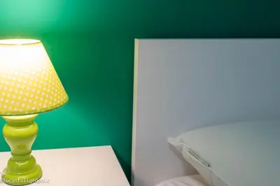 a lamp sitting on a table next to a bed at Sophie's Choice in Rome